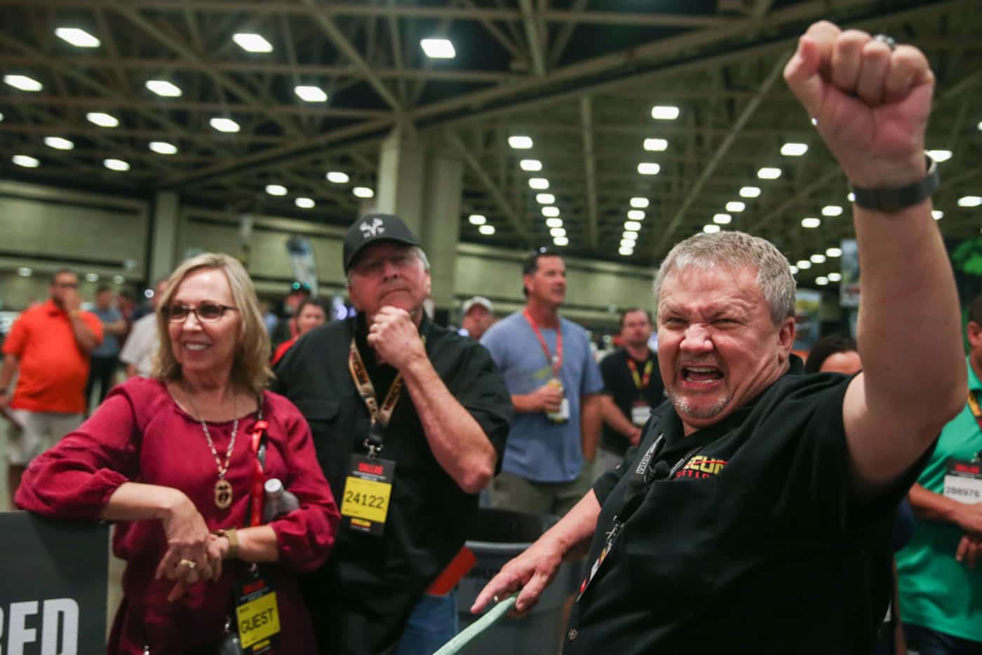 Ringman Ben Gunter (right) calls out a bid for Mike and Diana Hydrick of Pearl, Texas, for a...