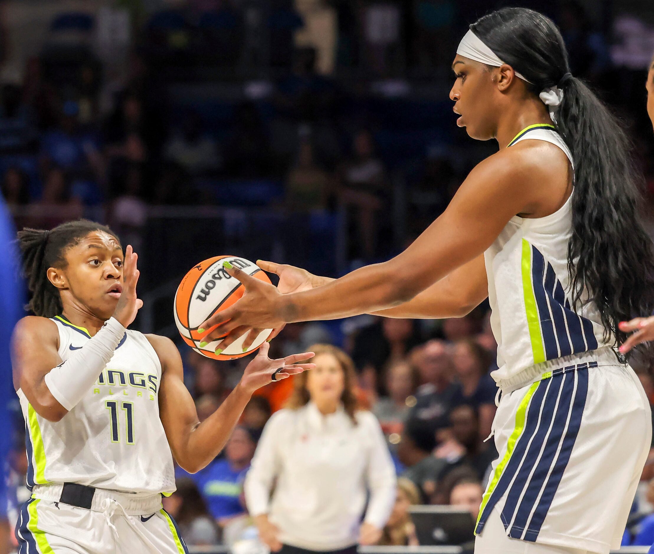 Dallas Wings guard Crystal Dangerfield (11) is is handed the ball by center Teaira McCowan...