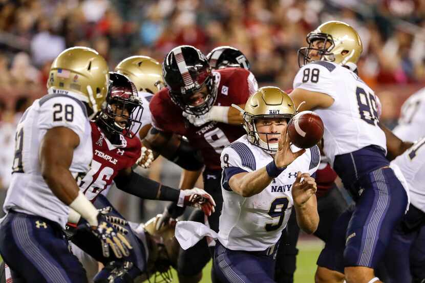 Navy quarterback Zach Abey (9) pitches to running back Josh Brown (28) against Temple in the...