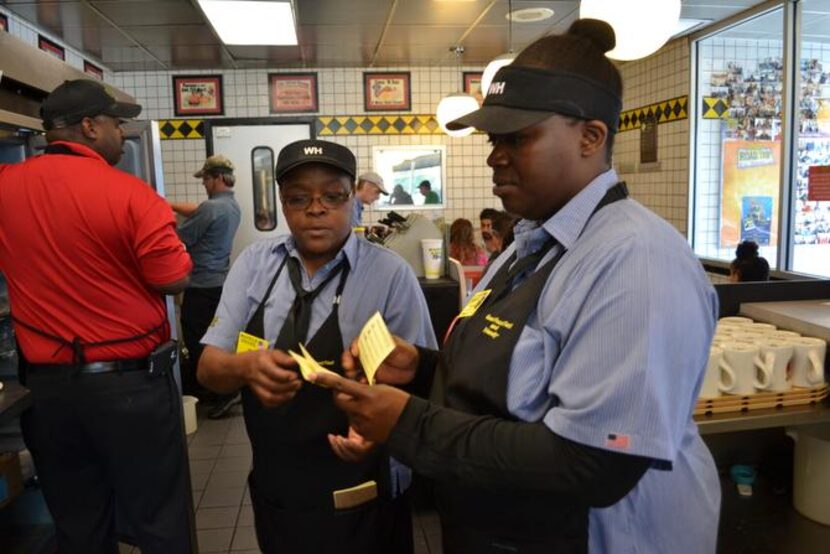 
Deanna Hall (right) reads off orders handed from waitress Rena Taylor (center) to manager...