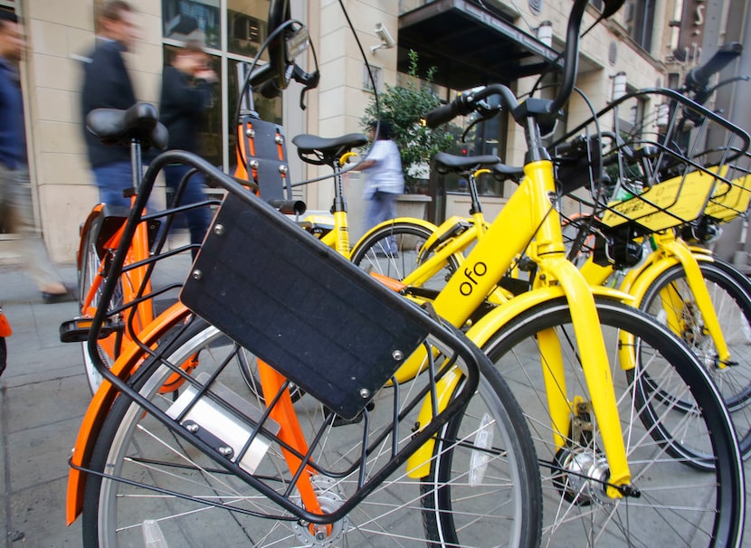 A damaged bike from Spin stands with bikes from other bike-share companies around downtown...