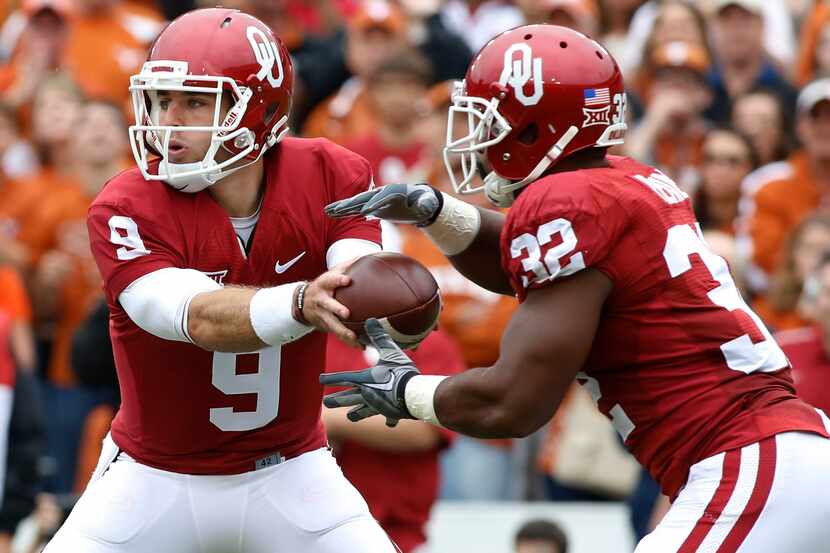 Oct 11, 2014; Dallas, TX, USA; Oklahoma Sooners quarterback Trevor Knight (9) hands off to...