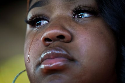 A tear runs down the cheek of MacKenzie Mitchell, one of the organizers, during a protest...