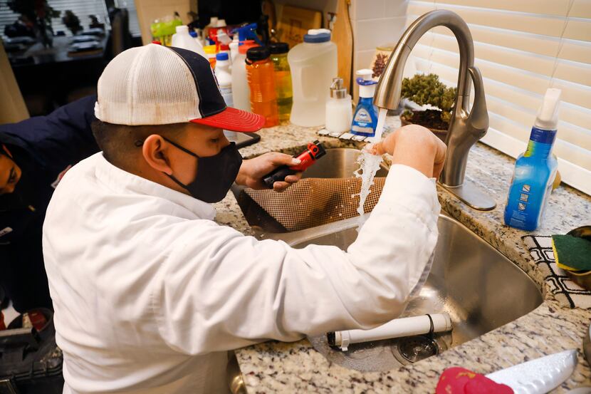 Plumber Geovanni Marino of Baker Brothers Plumbing tests the water after fixing a broken...