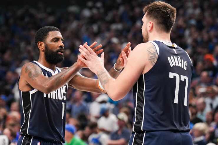 Dallas Mavericks guard Kyrie Irving (11) celebrates with guard Luka Doncic (77) during the...