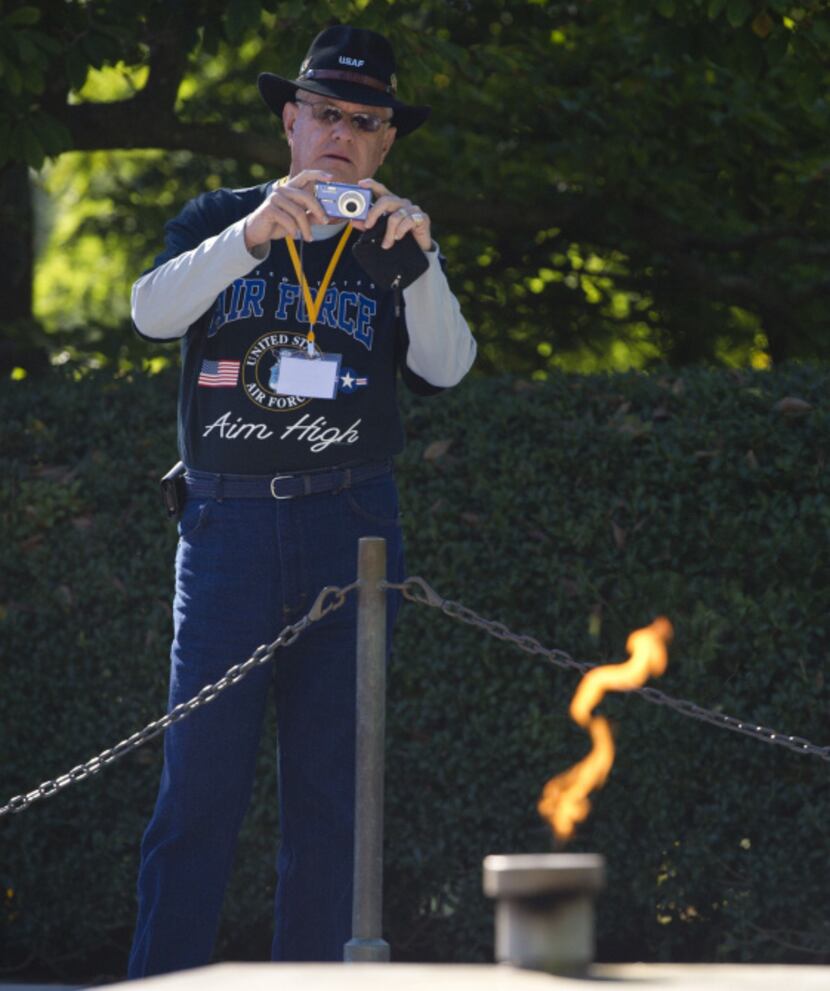 A tourist photographs the gravesite and eternal flame at the memorial of US President John...