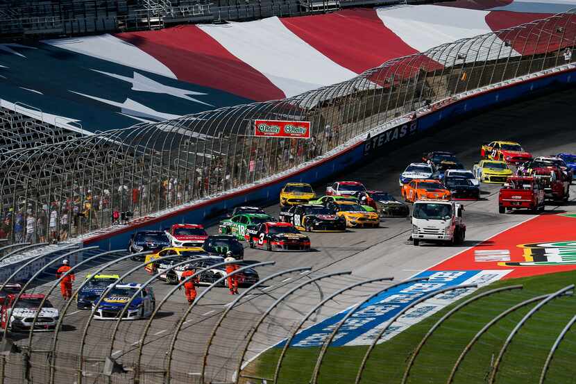 Fans line the fence to get photos of the stalled cars during the NASCAR Cup Series O'Reilly...
