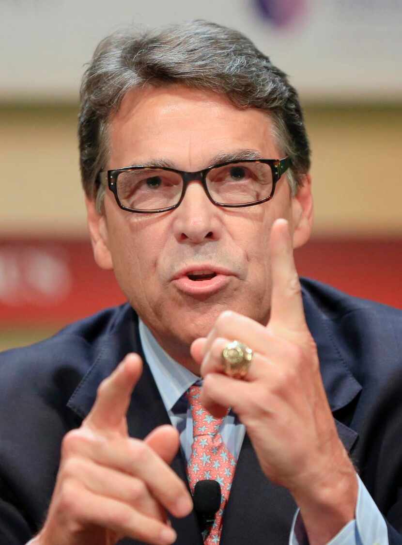 
Rick Perry, in famed glasses, says Donald Trump’s campaign is “a barking carnival act.”
