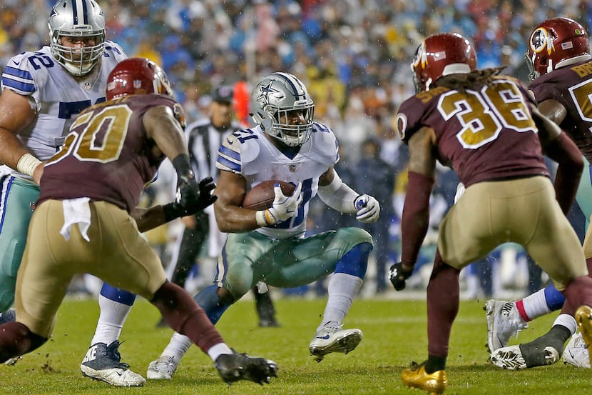 Dallas Cowboys running back Ezekiel Elliott (21) looks up for a running room between...