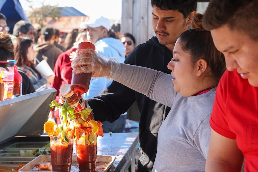 Mariana López (centro) prepara Micheladas en el puesto "Los Güeros" en La Pulga de Seagoville.