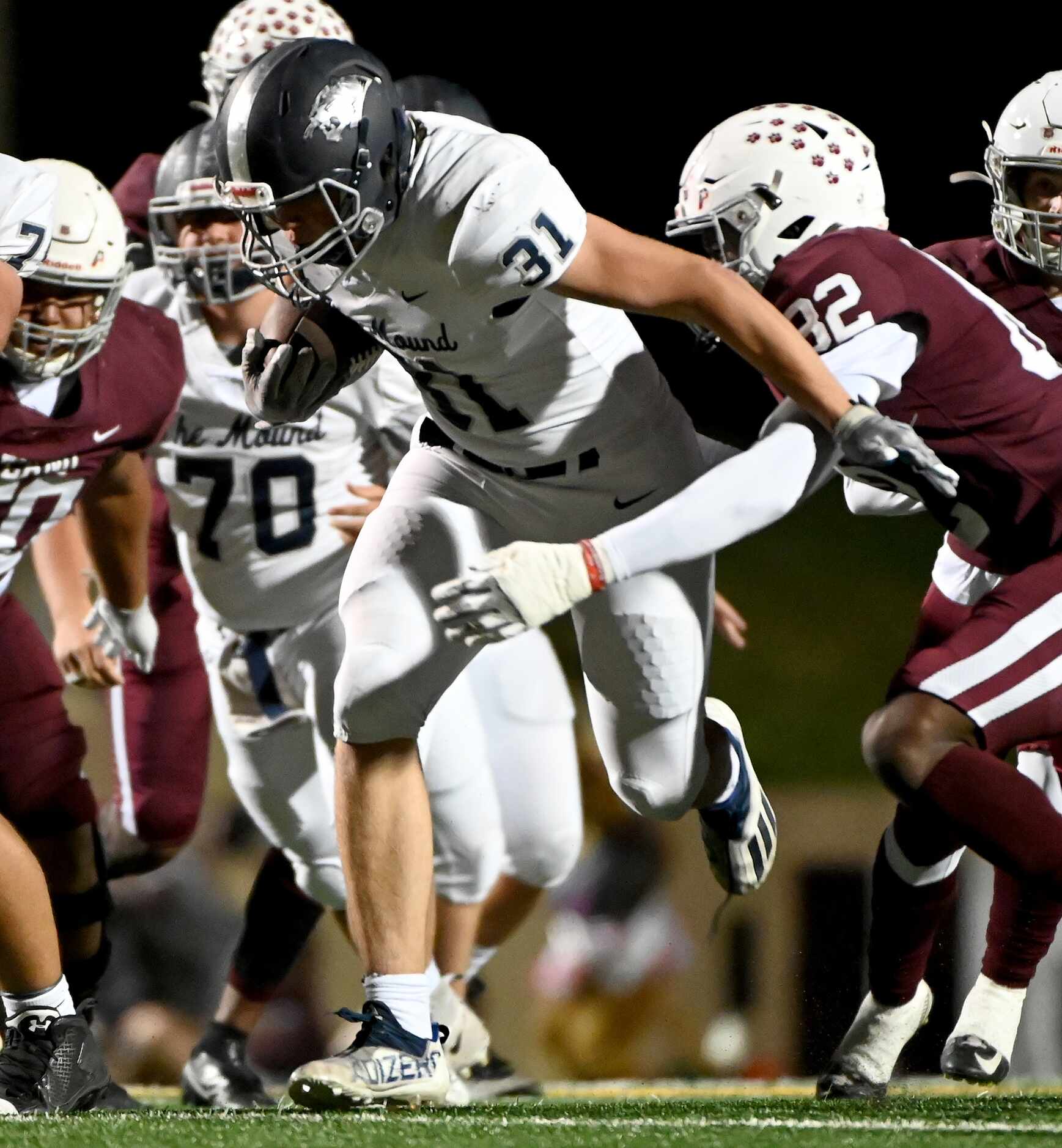 Flower Mound's running back Peyton Porter (31) tries to break a tackle by Plano's Jaxon Lee...
