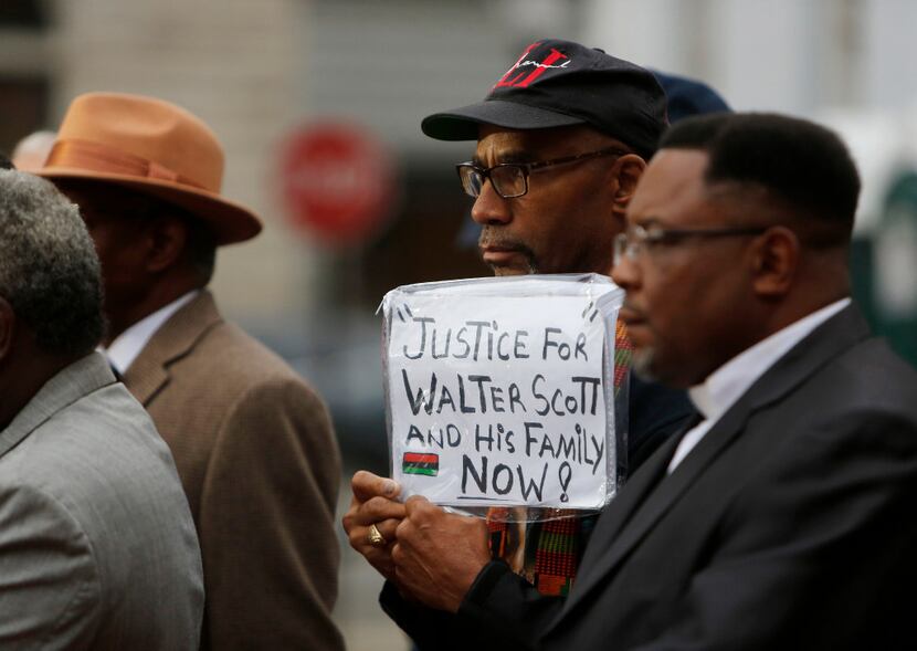 Dimitri Ford, from North Charleston, holds a sign supporting the Scott family during a...