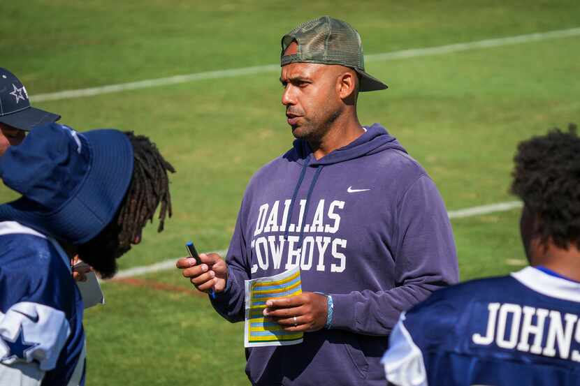 Dallas Cowboys defensive line coach Aden Durde talks with his players during a training camp...