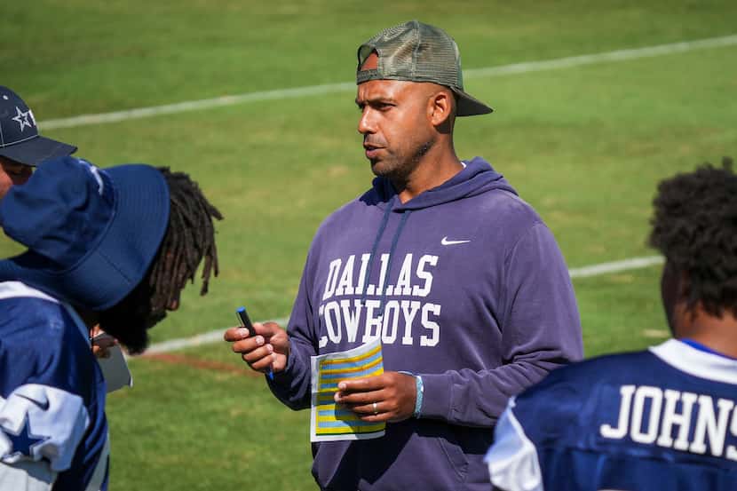Dallas Cowboys defensive line coach Aden Durde talks with his players during a training camp...