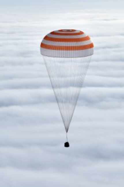 Russia's Soyuz TMA-18M space capsule descended through the clouds above Kazakhstan.