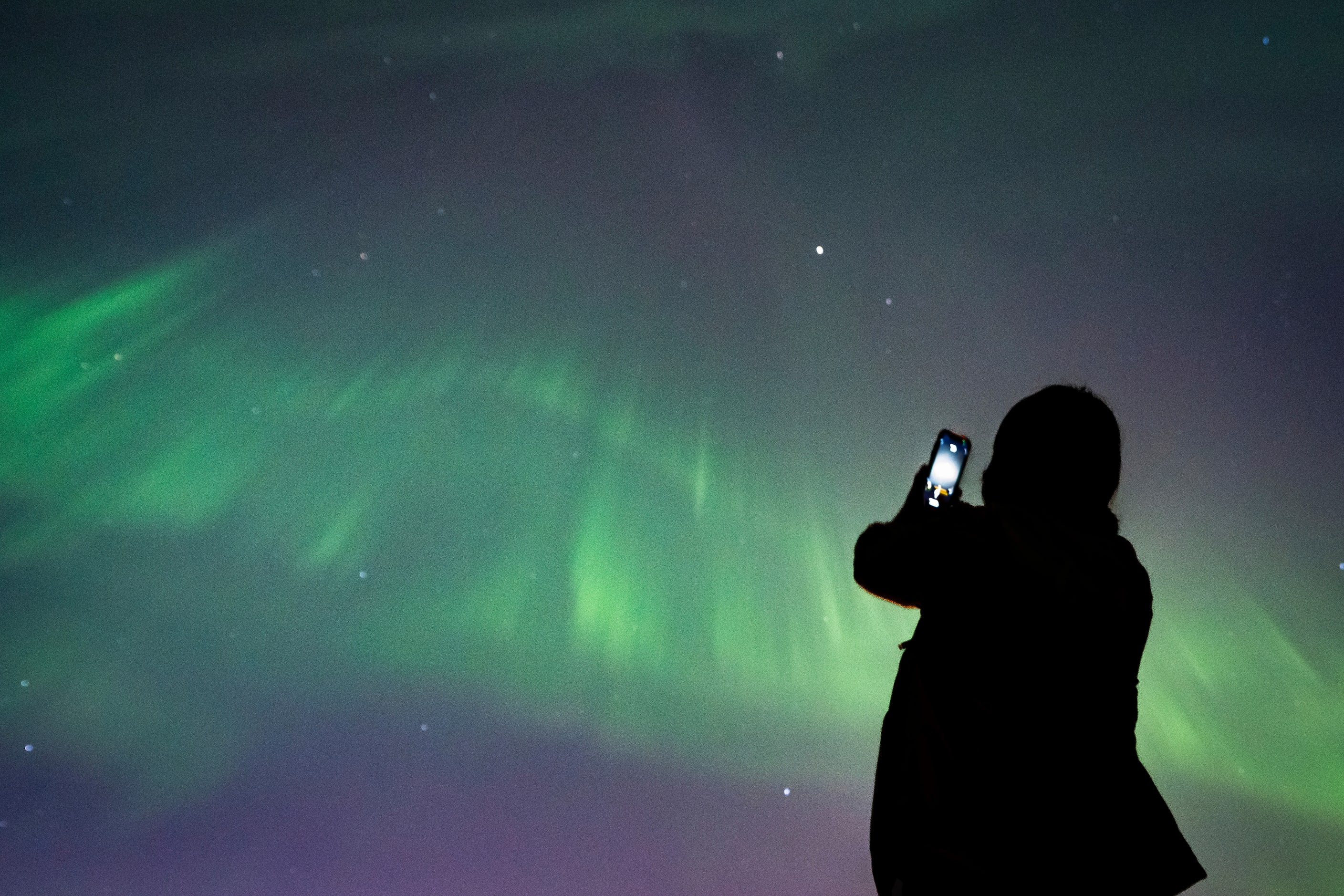 A person takes a photo of Aurora Borealis or the Northern Lights in Vancouver, B.C.,...