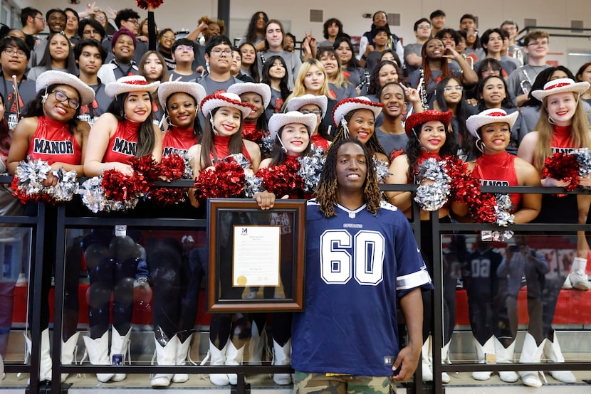 Dallas Cowboys left tackle Tyler Guyton, with the school drill team behind him, held a...