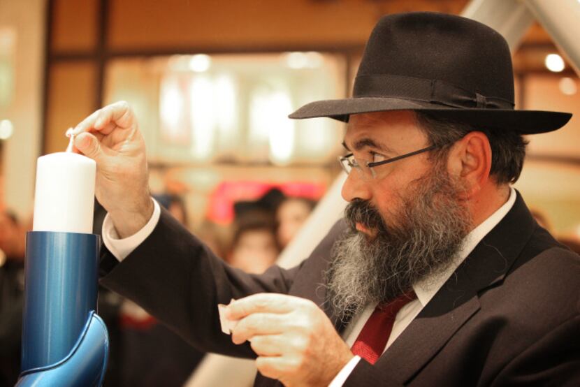 Rabbi Mendel Dubrawsky of the Chabad of Dallas lights the shamash of the community menorah...