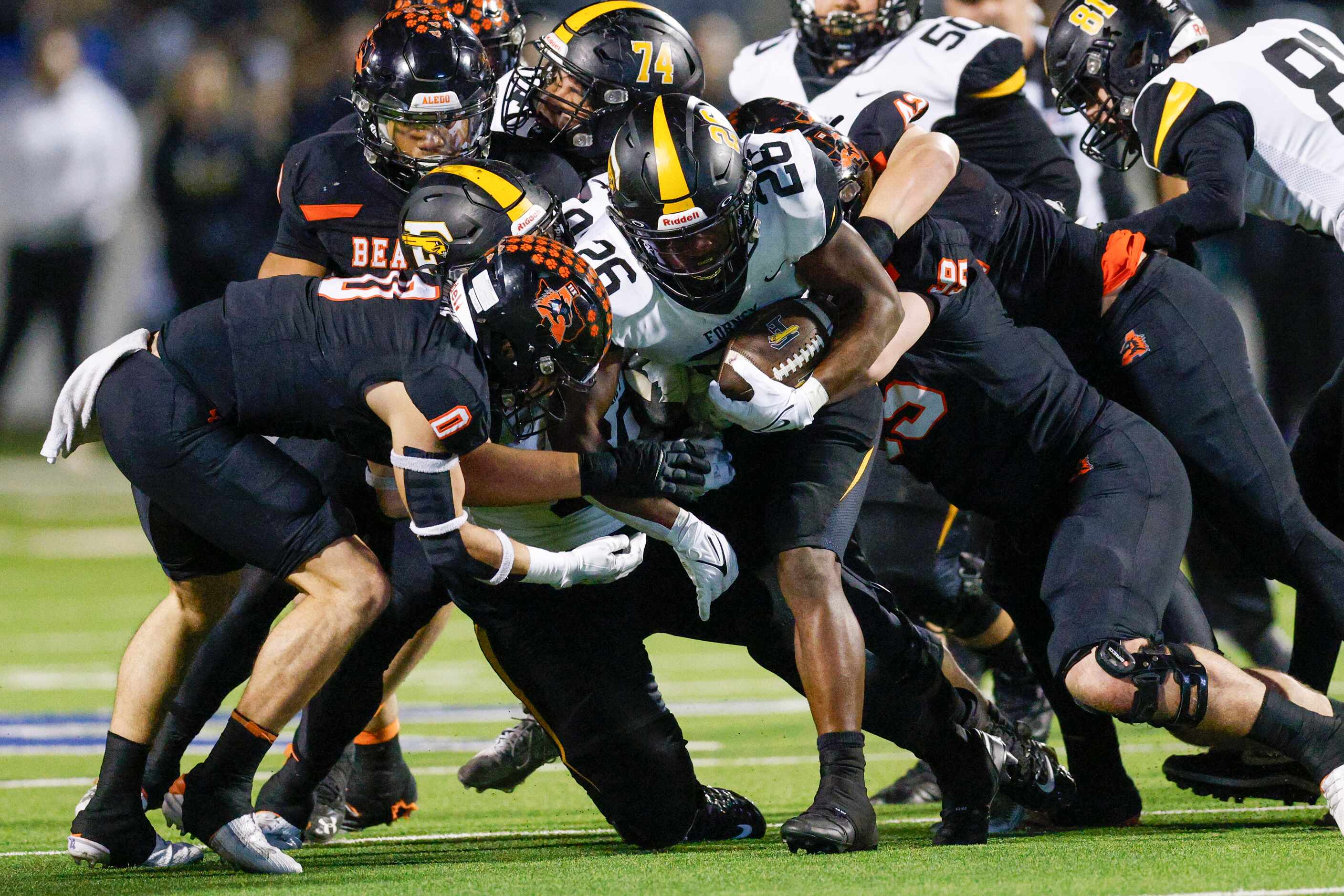Forney running back Javian Osborne (26) is brought down by a swarm of Aledo defenders during...