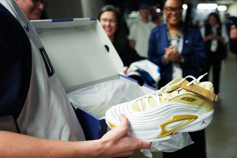 Make-A-Wish participant Thomas Marshall III unboxes a pair of shoes given to him by Dallas...