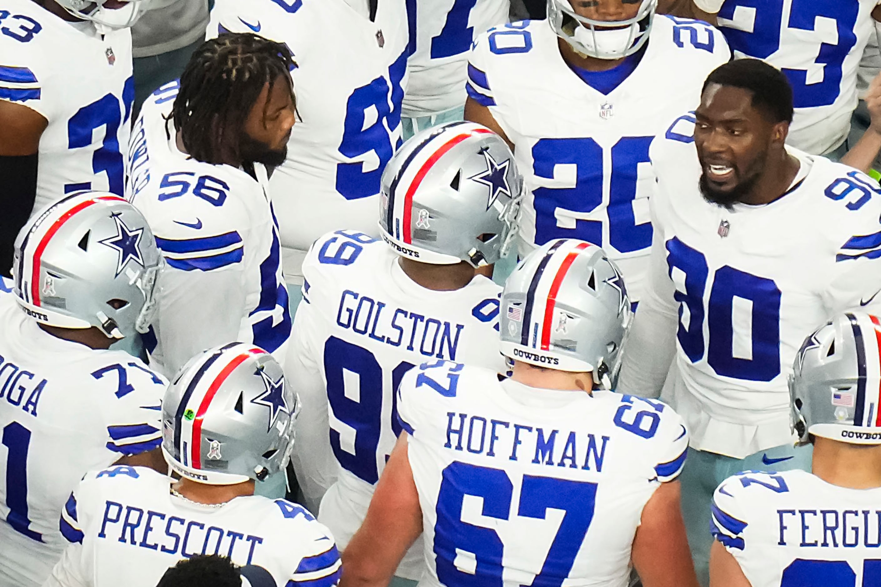 Dallas Cowboys players huddle around defensive end DeMarcus Lawrence (90) before an NFL...