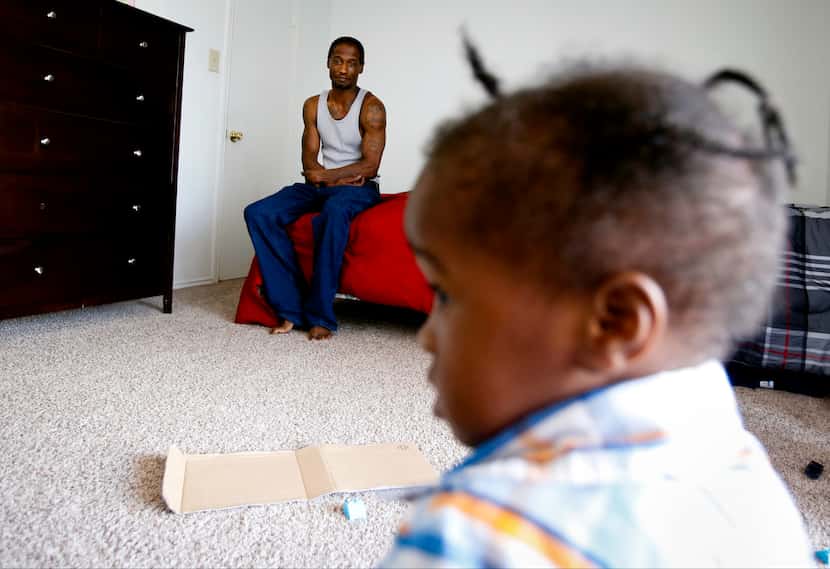 Joshua Miller watches Jordan play in their new apartment. After weeks of living in a room at...