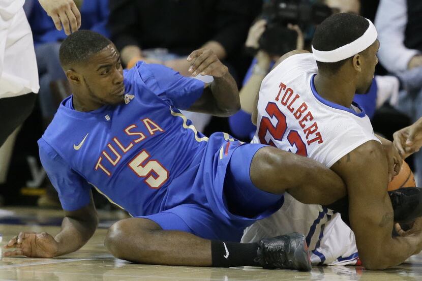 
Tulsa guard Rashad Ray (5) gets his foot tangled with SMU forward Jordan Tolbert (23)...