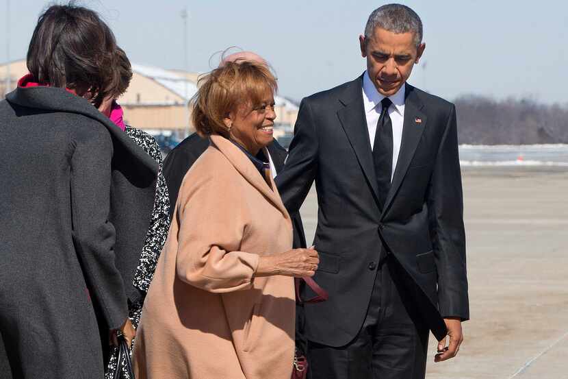 Marian Robinson, mother of first lady Michelle Obama, center left, smiles as she boards Air...