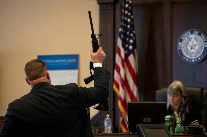 Attorney Jason Webster of Houston, who is representing victims' families, shows a Ruger...