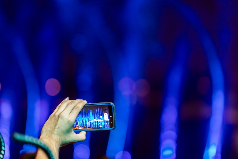 A spectator uses his phone to capture video of the Illuvia Fountain Show at Epic Central in...