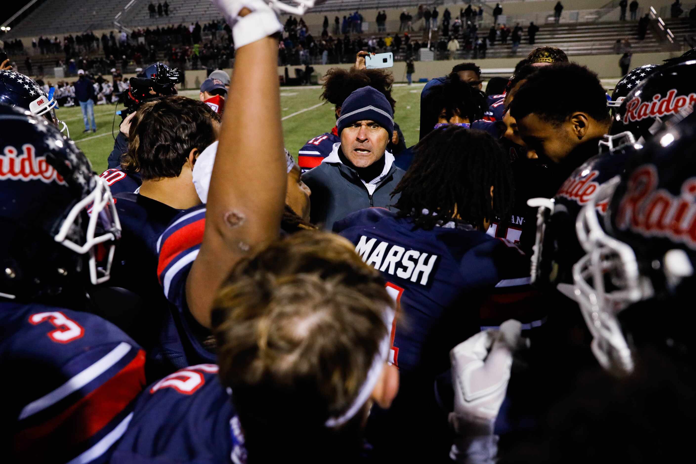 Denton Ryan football coach Dave Henigan celebrates with his players after winning the...