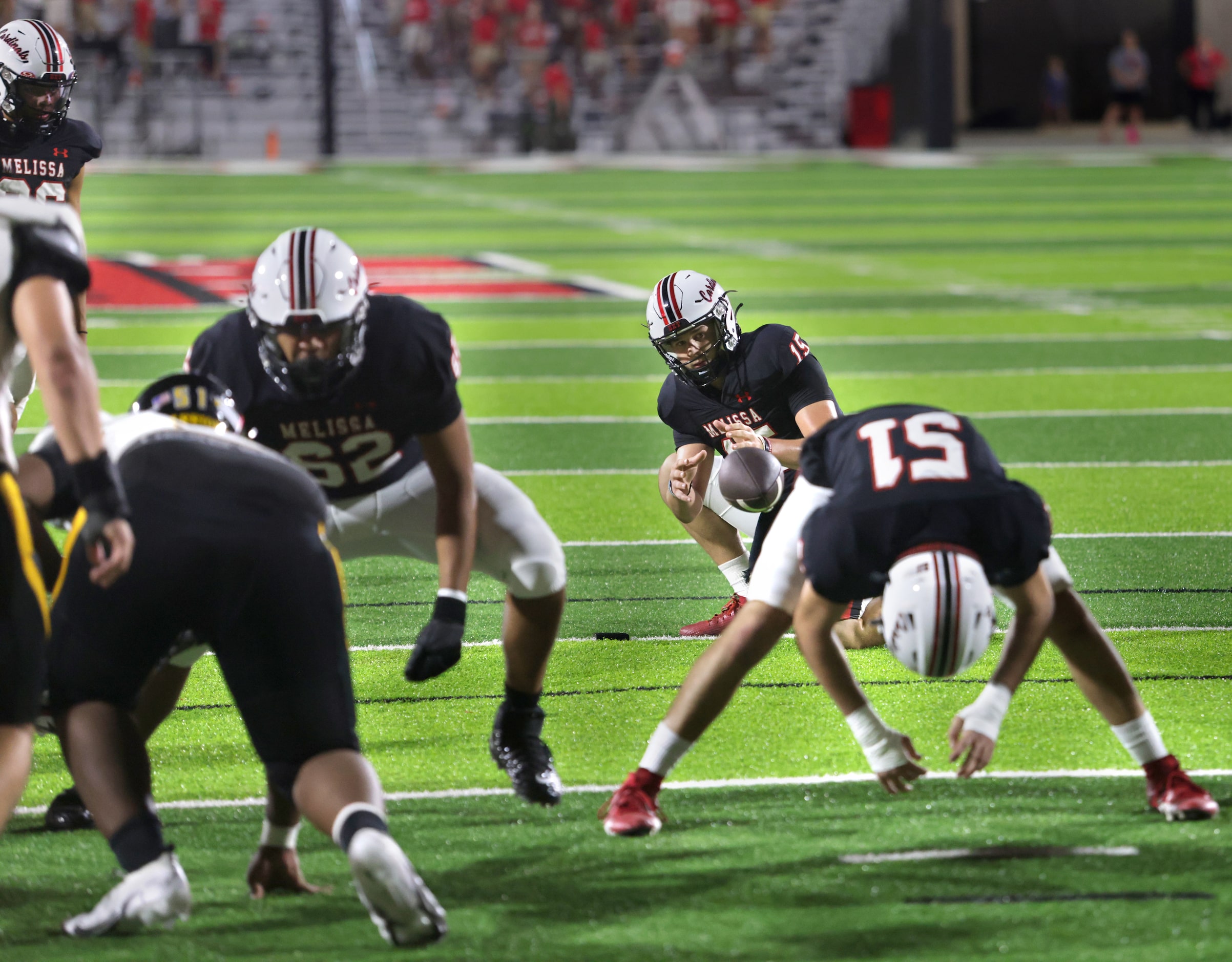 Melissa player #15 Tate Kirk receives the field goal snap during the Frisco Memorial High...