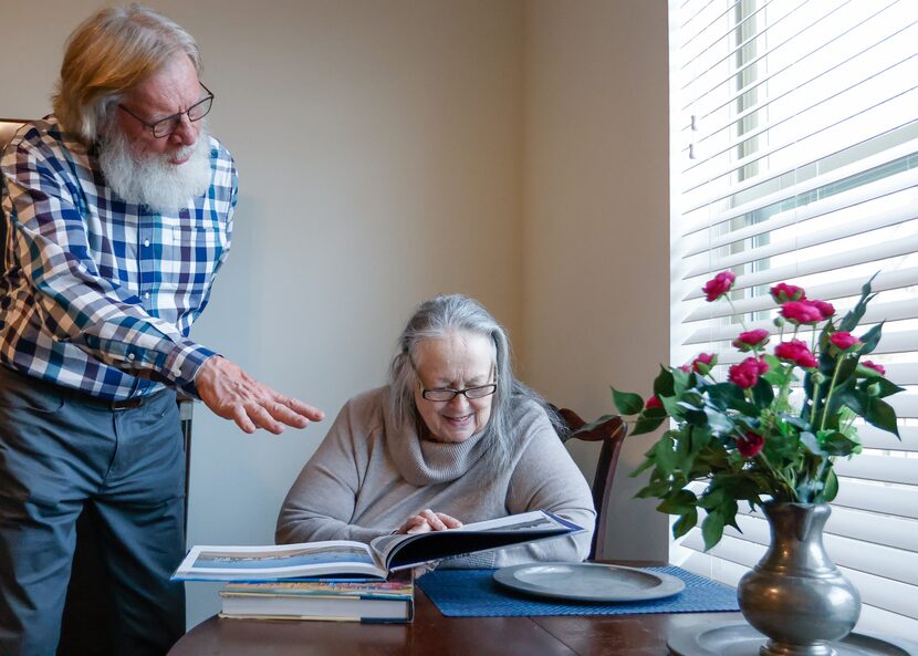 Chuck Stegman (left) talks with Poldi Tonin over a new book in her living room at Juliette...