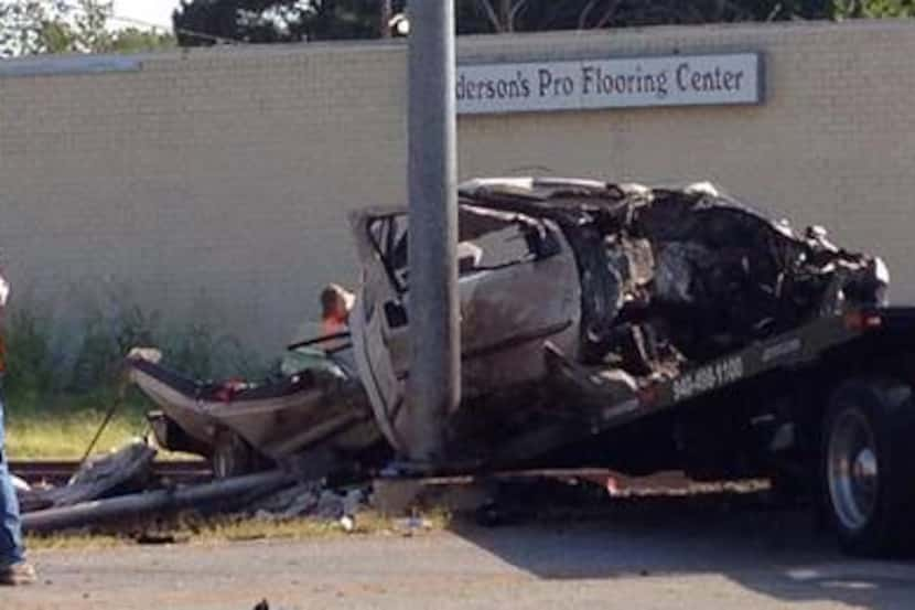 Workers prepared to haul away the remnants of a pickup that was hit by the A-train at a...