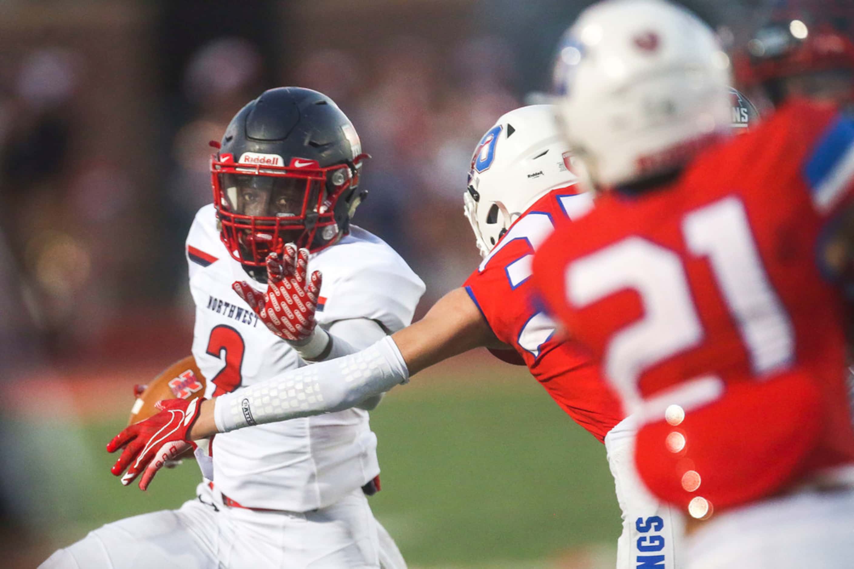 Northwest's Zavion Taylor (2) caries the ball past Grapevine's defenders during the first...