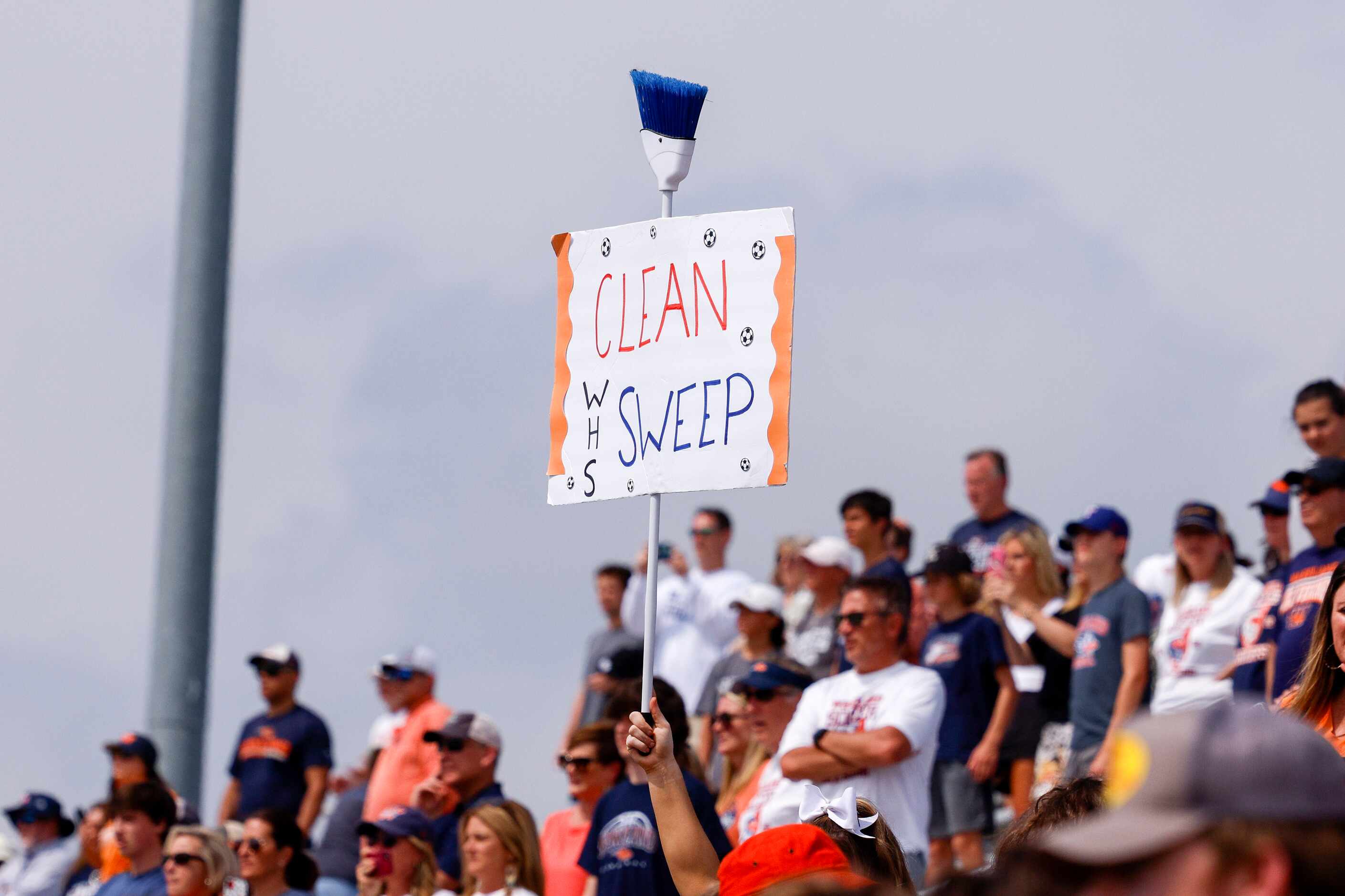 A Frisco Wakeland fan raises a broom and sign after winning the Class 5A boys soccer state...
