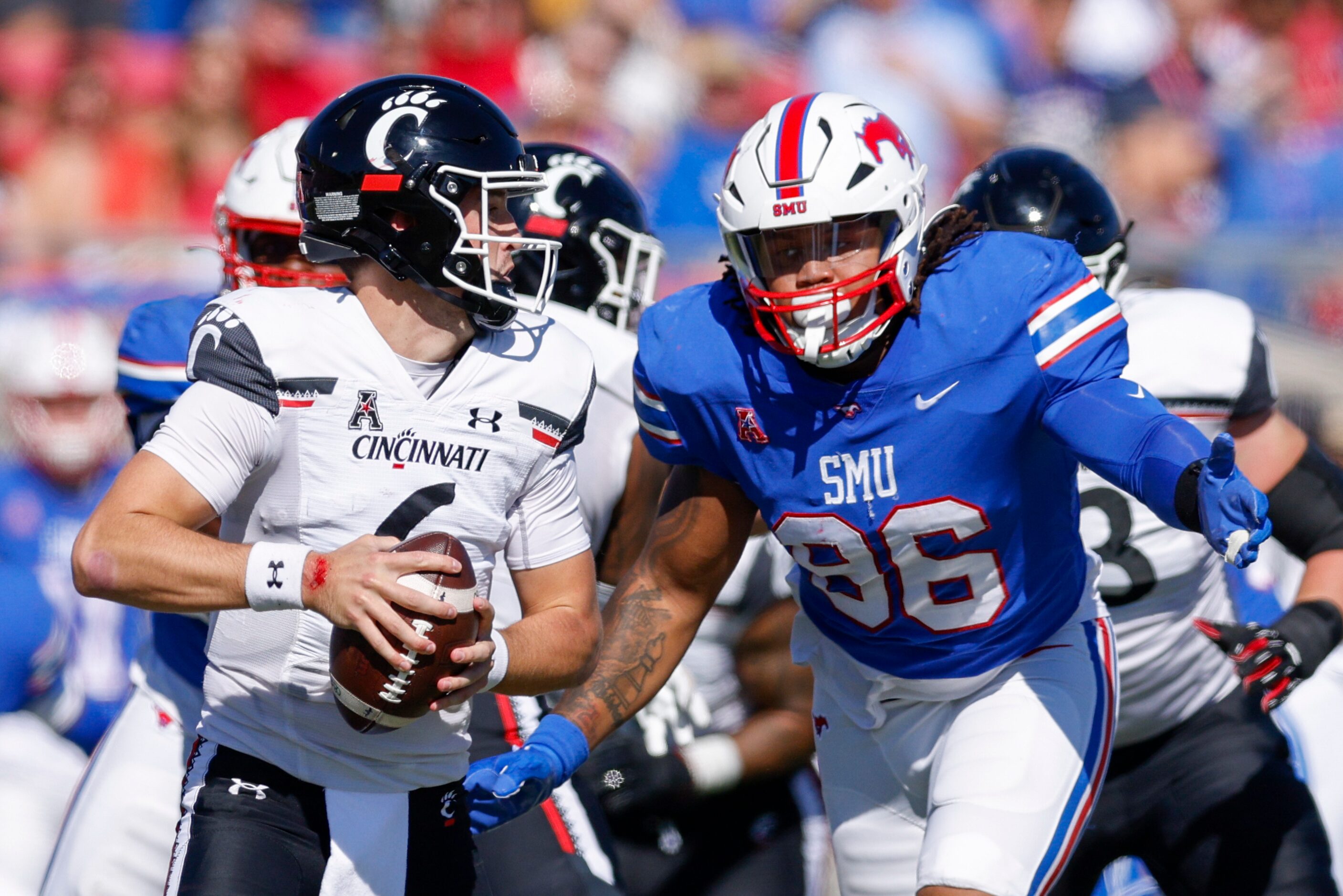 SMU defensive tackle DeVere Levelston (96) rushes Cincinnati quarterback Ben Bryant (6) for...