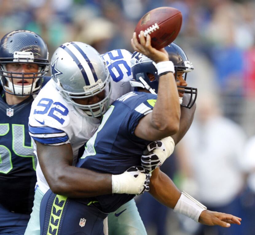 Dallas Cowboys nose tackle Josh Brent (92) tackles Seattle Seahawks quarterback Russell...