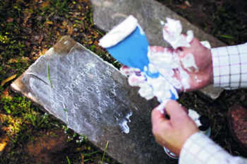 Cleve Hasten cleaned up shaving cream after applying it to a grave marker to try to read its...