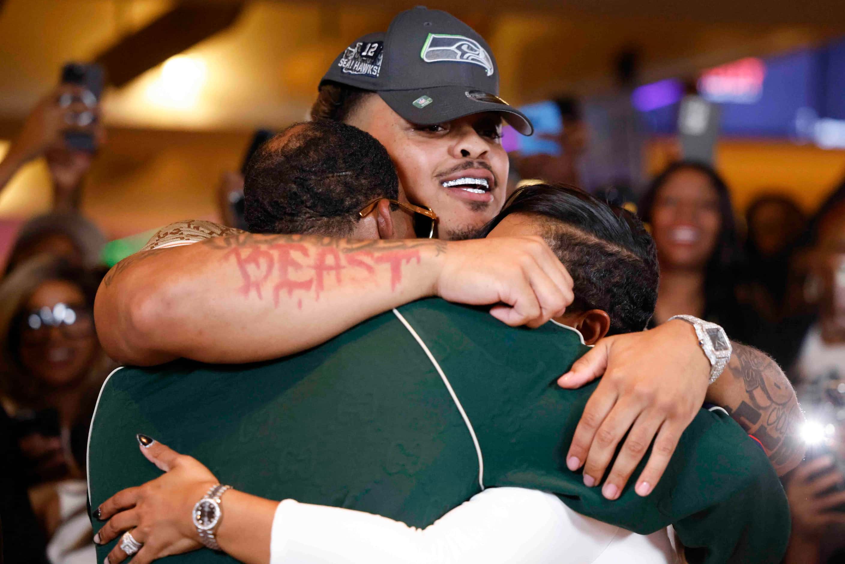  Texas defensive tackle Byron Murphy II, (center) from DeSoto, embraces his father Byron...