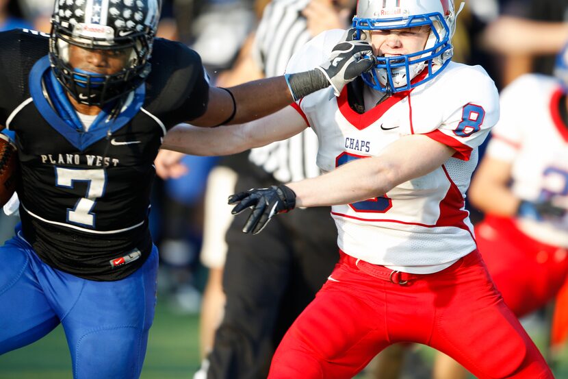 Plano West's Auston Anderson (7) grabs a hold of Austin Westlake's John Dodd's (8) helmet...