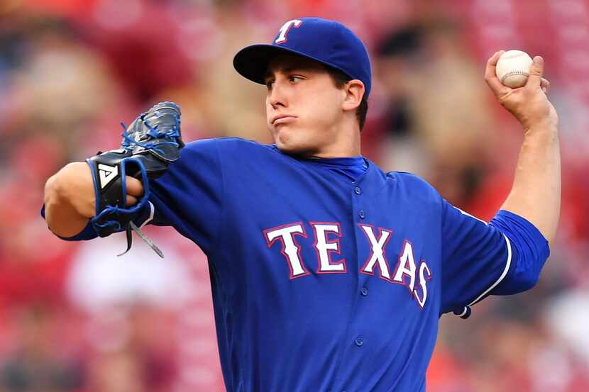 CINCINNATI, OH - AUGUST 23:  Derek Holland #45 of the Texas Rangers pitches in the second...