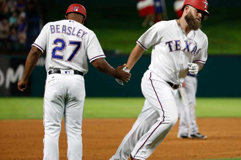 Texas Rangers first baseman Mike Napoli (5) fives Texas Rangers third base coach Tony...