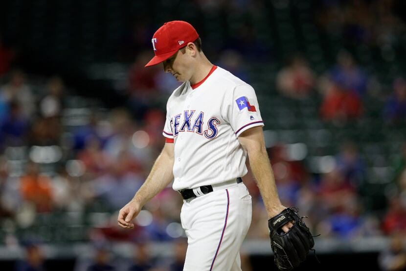 Texas Rangers closer Sam Dyson walks to the dugout after the top of the 10th inning of a...