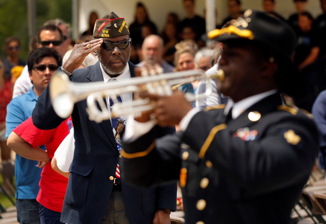 Retired Vietnam War Army veteran Clarence Jackson salutes as Taps is played by Spc. Phillip...
