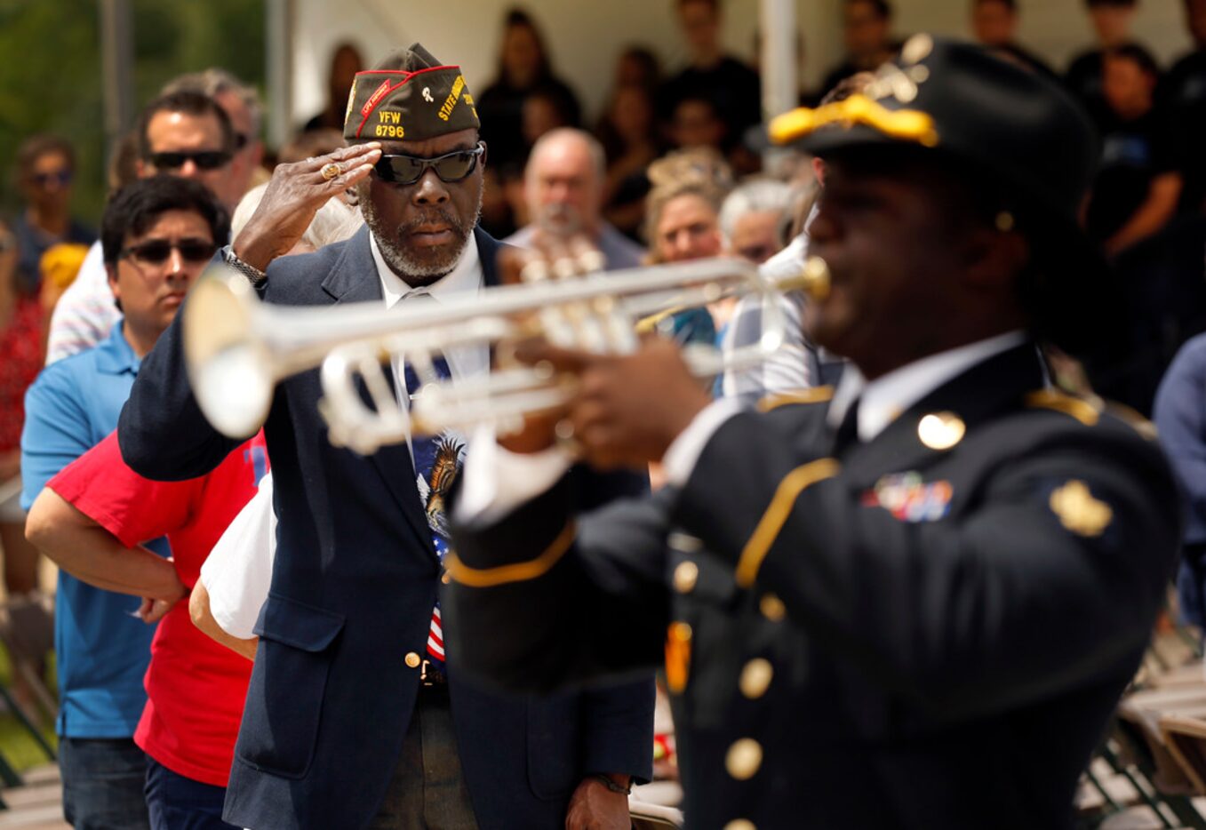 Retired Vietnam War Army veteran Clarence Jackson salutes as Taps is played by Spc. Phillip...