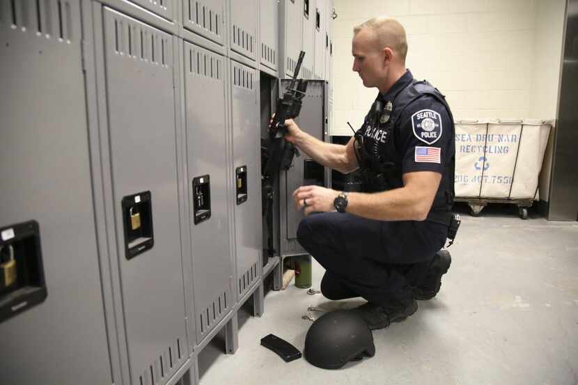 Officer Michael Virgilio retrieves an AR-15 from his locker at the start of a shift in...