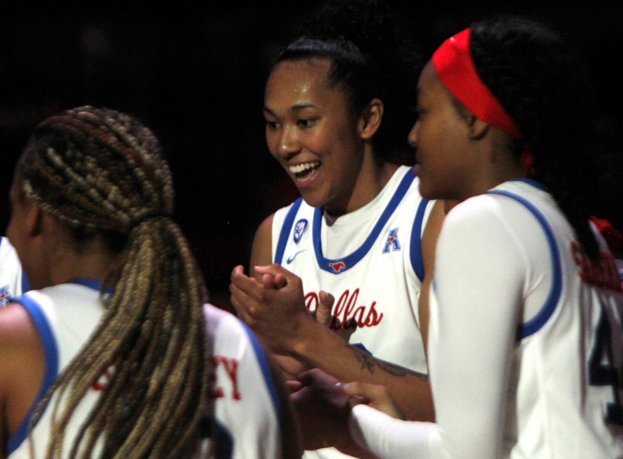 SMU forward Savannah Wilkinson (12), center, shares a light moment with teammates following...