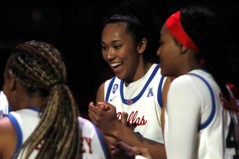 SMU forward Savannah Wilkinson (12), center, shares a light moment with teammates following...