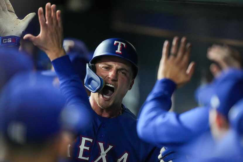 Texas Rangers shortstop Corey Seager (5) celebrates with teammates after hitting a solo home...
